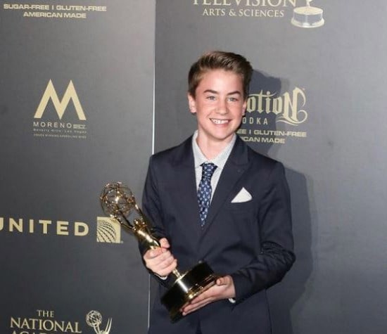 Picture of Isaac Kragten posing for a photoshoot with award on his hand